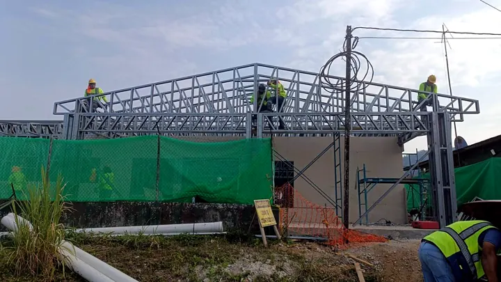 Cuadrilla montando cerchas de cubierta en Steel Framing sobre muros de una edificación institucional